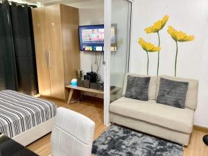 a living room with a couch and a tv at Azure Staycation Magical Suite in Manila