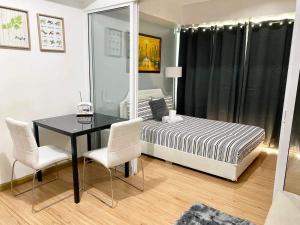 a bedroom with a bed and a table and chairs at Azure Staycation Magical Suite in Manila