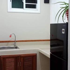 uma cozinha com um lavatório e um frigorífico preto em Mem Homestay 
