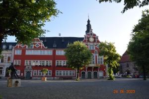 um grande edifício vermelho com uma torre de relógio em Zur Pforte em Arnstadt