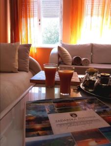 Apartment Puhov Zadar في زادار: غرفة معيشة مع أريكة وطاولة مع مشروبات عليها