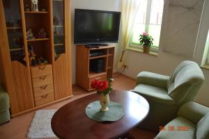 a living room with a table and a television at Zur Pforte in Arnstadt