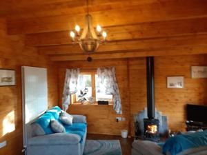 a living room with a couch and a fireplace at Bishy Barnabees country lodge with hot tub in Swaffham +13 photos