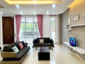 a living room with two couches and a tv at MODERN STYLISH 2STOREY HOUSE 8PAX@ALMA NEAR JUSCO in Bukit Mertajam