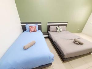 duas camas sentadas uma ao lado da outra num quarto em MODERN STYLISH 2STOREY HOUSE 8PAX@ALMA NEAR JUSCO em Bukit Mertajam