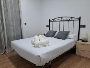 a bedroom with a large bed with towels on it at Puerta del Vado Bajo in Toledo