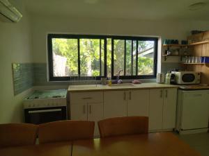 a kitchen with a sink and a large window at מקום לנשום בית אירוח in Sheʼar Yashuv