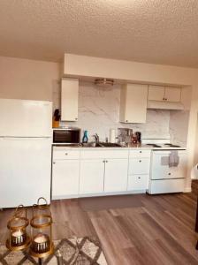 a kitchen with white cabinets and white appliances at North Star Place Apt 12 (premium) in Fairbanks +4 photos