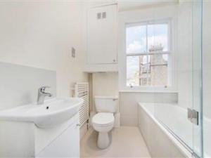uma casa de banho branca com um WC e um lavatório em Lovely 2-beds flat in the heart of Knightsbridge em Londres