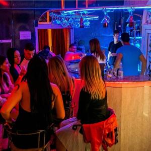 een groep mensen die aan een bar zitten bij Private Party Villa in Boedapest