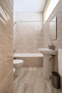 La salle de bains est pourvue d'un lavabo, de toilettes et d'une baignoire. dans l'établissement Convenient 3-Bedroom Apartments next to Bom Sucesso, à Porto