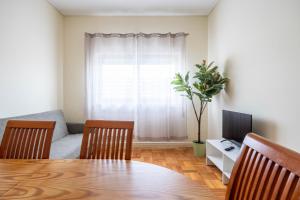 un salon avec une table, deux chaises et une télévision dans l'établissement Convenient 3-Bedroom Apartments next to Bom Sucesso, à Porto
