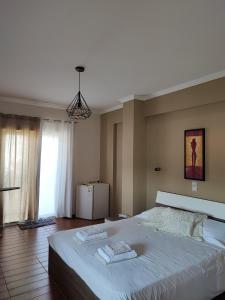 - une chambre avec un grand lit et 2 serviettes dans l'établissement A cozy whole house near the airport and the beach, à Artemi