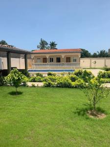 una casa grande con dos árboles en un patio en pavillon « lilas » à dagué-togo en Dagé