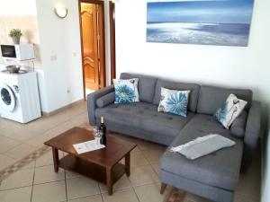 ein Wohnzimmer mit einem Sofa und einem Tisch in der Unterkunft Casa Morgana in Playa Blanca