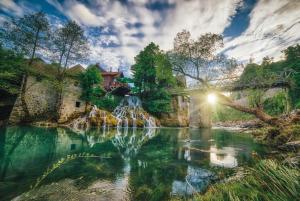 a bridge over a pond with a waterfall at Apartment Dado in Slunj