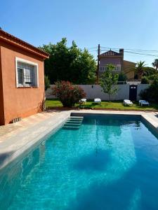 Chalet con piscina cerca playa في La Venteta: مسبح ازرق كبير بجوار منزل