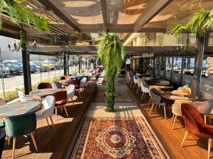een restaurant met tafels, stoelen en ramen bij Sea View Private Studio Paradiso B 508 in Nesebar