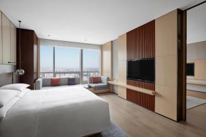 um quarto de hotel com uma cama e uma televisão de ecrã plano em Shenyang Marriott Hotel em Shenyang