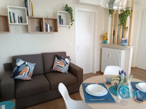 a living room with a couch and a table at Attico Gabri - Appartamento con terrazzo panoramico vicino al Centro in Turin