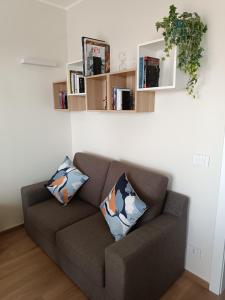 a couch with two pillows in a living room at Attico Gabri - Appartamento con terrazzo panoramico vicino al Centro in Turin +31 photos