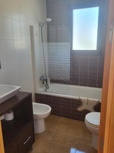 ein Badezimmer mit einer Badewanne, einem WC und einem Waschbecken in der Unterkunft Ático Loft Vera Playa in Vera