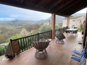 a patio with a table and chairs on a balcony at La paresse in Avèze