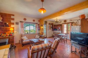 a living room with a television and a table and chairs at Bonavista (Batle De Bonavista) in Felanitx