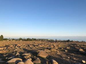 un gran grupo de rocas en un campo en Guest house Hygge en Cholpon-Ata