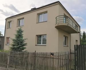 a white house with a fence in front of it at Apartament Park Redena in Chorzów