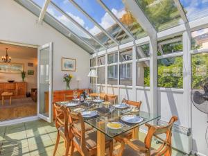 a conservatory with a dining room with a table and chairs at 7 Roundham Heights in Paignton