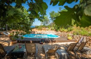 un patio trasero con piscina y sillas en Rock Oak Camp, en Imotski