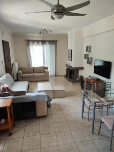 - un salon avec un canapé et une télévision dans l'établissement A cozy whole house near the airport and the beach, à Artemi