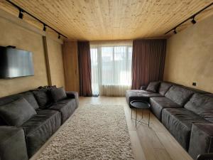 ein Wohnzimmer mit einem Sofa und einem TV in der Unterkunft Townhouse in Mountains. in Bakuriani