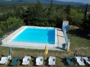 einen Pool im Garten mit Stühlen und Sonnenschirmen in der Unterkunft Domaine La Fontaine Du Cade in Lagorce