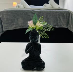 una statua nera con un vaso di fiori su un tavolo di Schönes zentrales Appartment mit TIEFGARAGE a Kassel