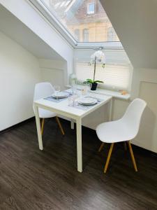 a white dining room table with two chairs and a window at Schönes zentrales Appartment mit TIEFGARAGE in Kassel