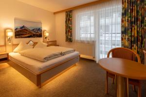 a bedroom with a bed and a table and a window at Gidis Hof in Ischgl