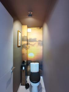 a bathroom with a toilet with a painting on the wall at Marina dream in Toulon