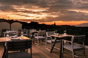 a restaurant with tables and chairs with a sunset in the background at Hotel St.John Suites Adults Only in Tsilivi