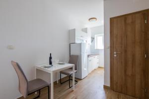 a small white table and chairs in a kitchen at Apartments M in Seget Vranjica
