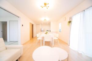 sala de estar con mesa blanca y sillas en Nagashima Riverside Condominium, en Hakuro