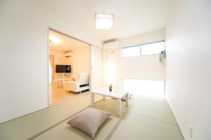 sala de estar con mesa blanca y ventana en Nagashima Riverside Condominium, en Hakuro