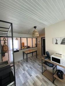 Vensac的住宿－L'abri côtier，客厅配有桌子和微波炉
