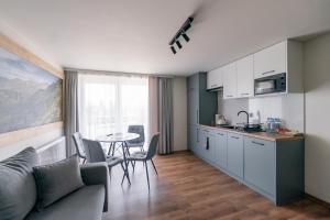 eine Küche und ein Wohnzimmer mit einem Sofa und einem Tisch in der Unterkunft Apartamenty Przy Ścieżce Velo Czorsztyn in Dębno