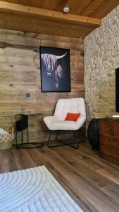 Le Refuge du Montagnard في Marthod: غرفة معيشة بها كرسي أبيض وتلفزيون