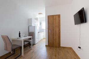 a living room with a table and a television and a door at Apartments M in Seget Vranjica