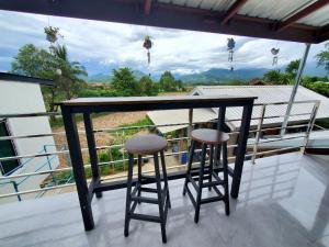 - un balcon avec un bar et deux tabourets dans l'établissement สวัสดีปัวโฮมสเตย์ Sawaddee Pua Homestay, à Pua