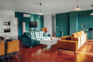 a living room with green walls and a blue couch at Design 3BD apartment cooking area in architect villa in Prague