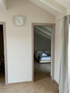 - une horloge sur un mur dans une chambre avec un lit dans l'établissement Cozy City Loft, à Argostóli